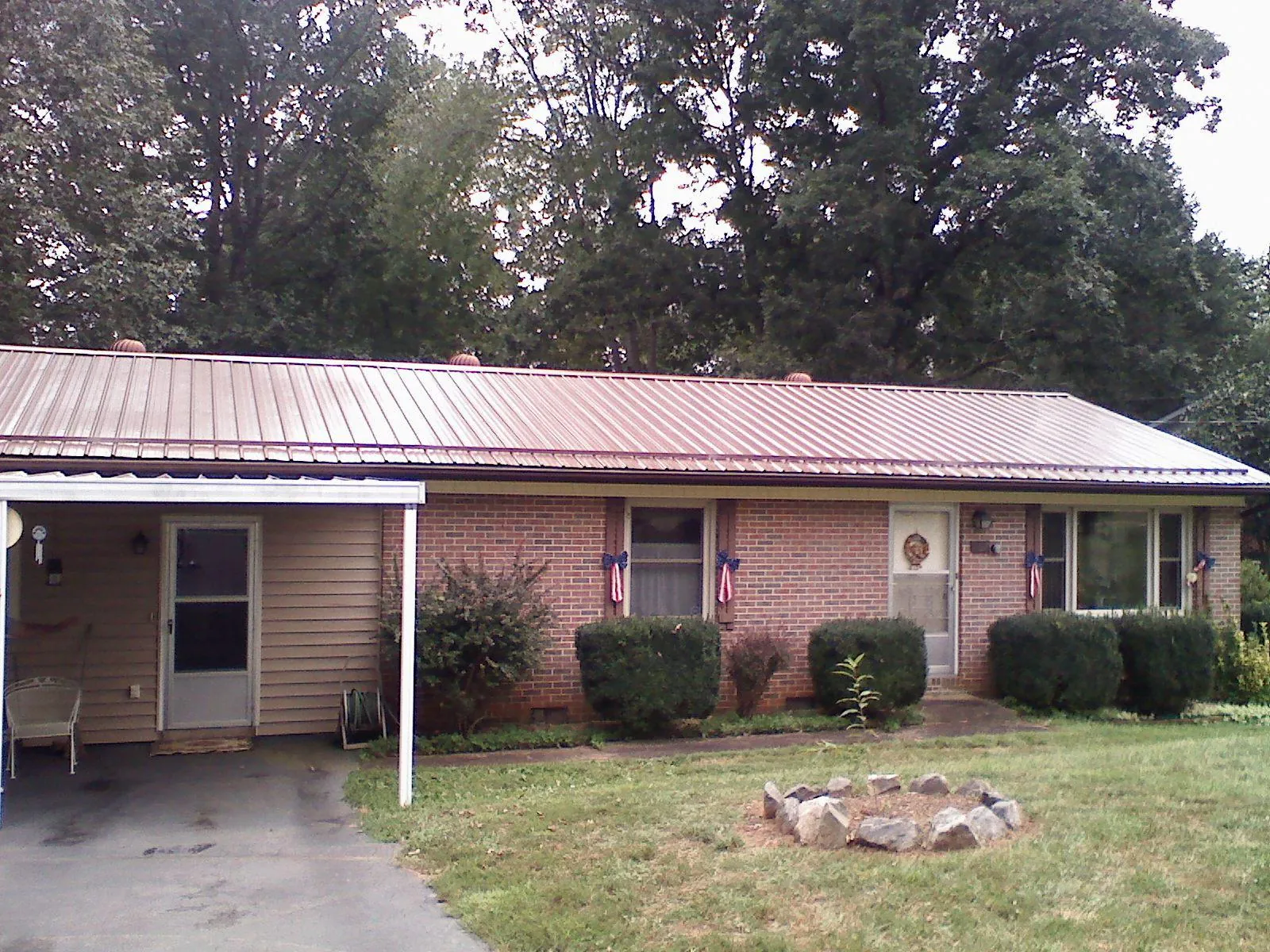 Bronze metal roof and carport on a brick ranch home — Roof Repair work by our crew in Port Washington